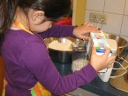 Kind schüttet Milch in einen Messbecher