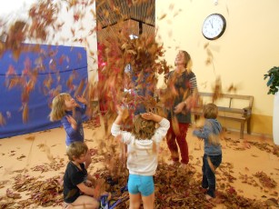 Kinder im Blätterregen in einem Raum